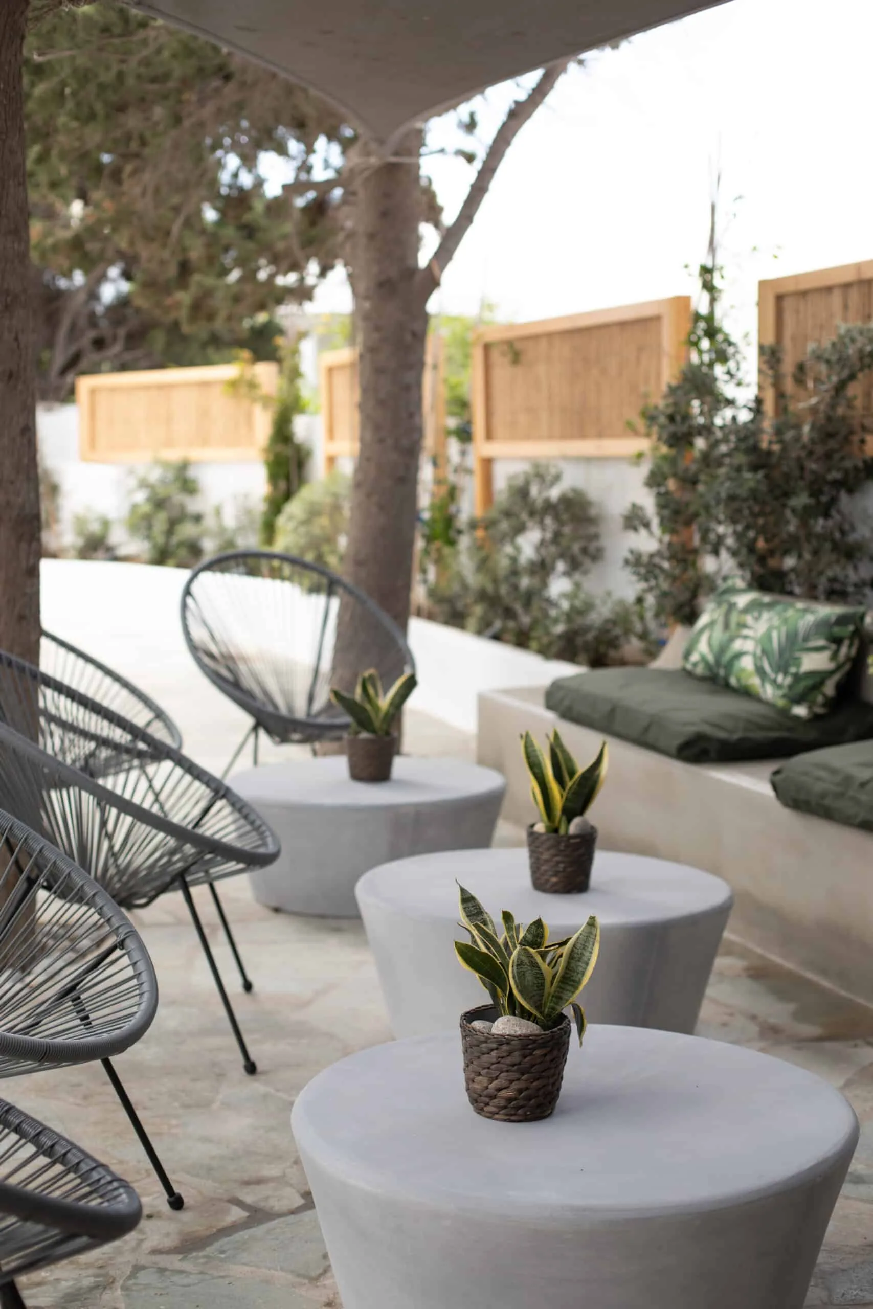 Rope chairs and side tables on a shaded terrace